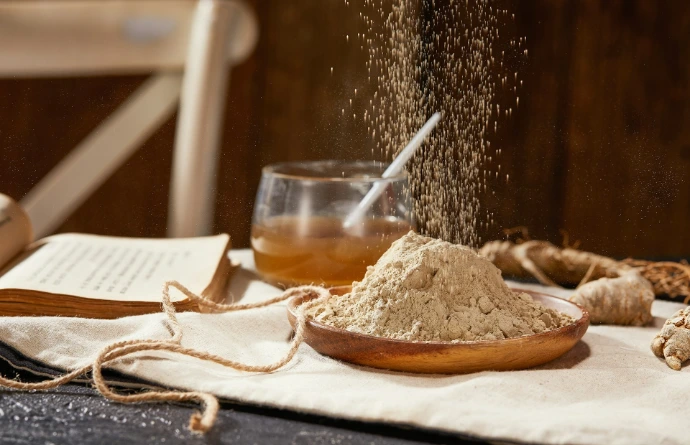 a table topped with a wooden bowl filled with sand